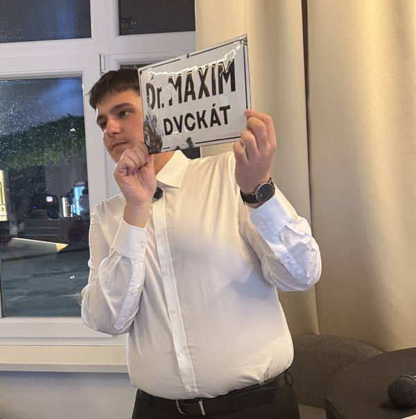 Samuel Šabak showing the “Dr. Maxim advokát” nameplate